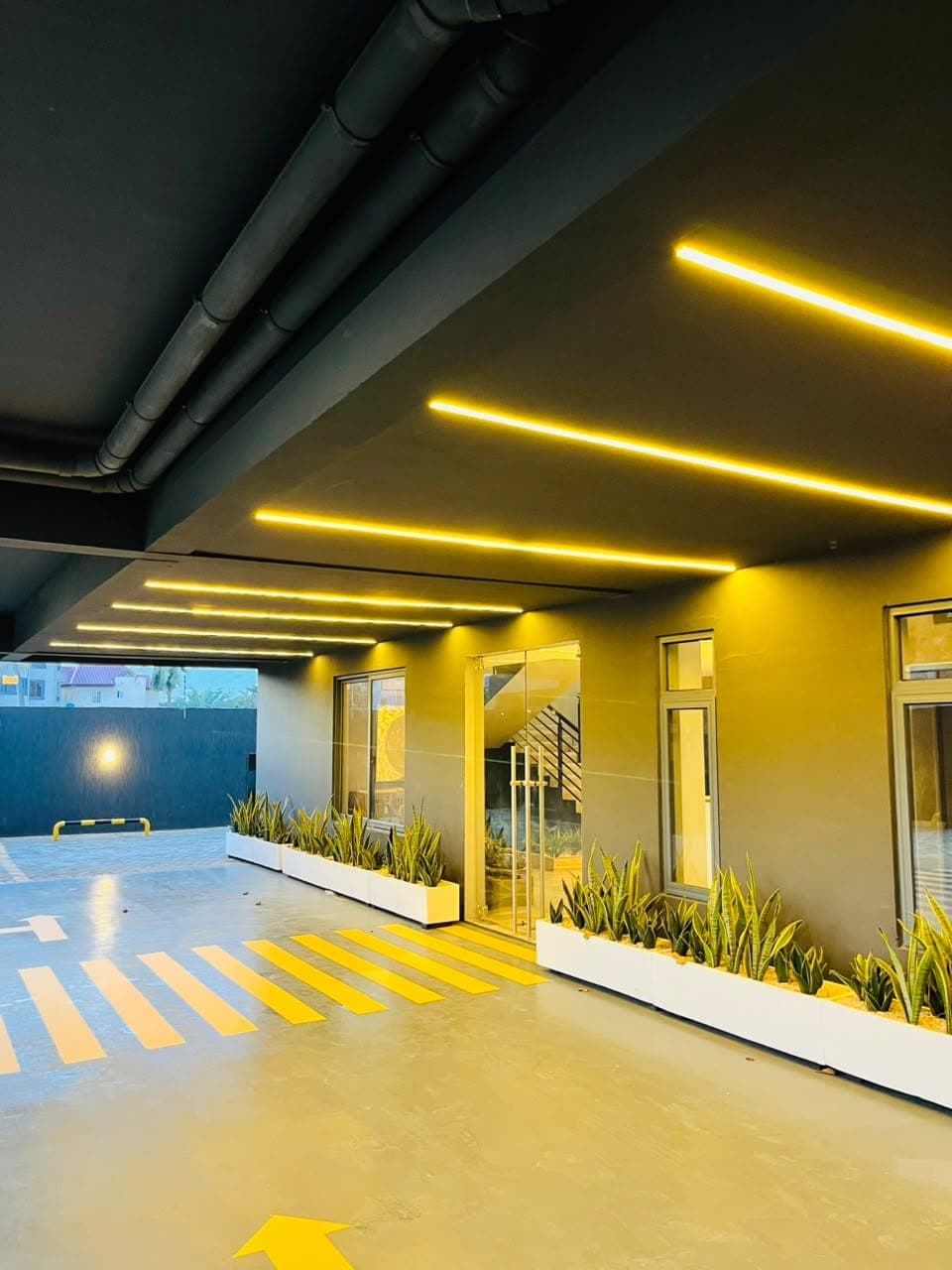 Completed yellow pedestrian crossing and directional arrows in a painted car park