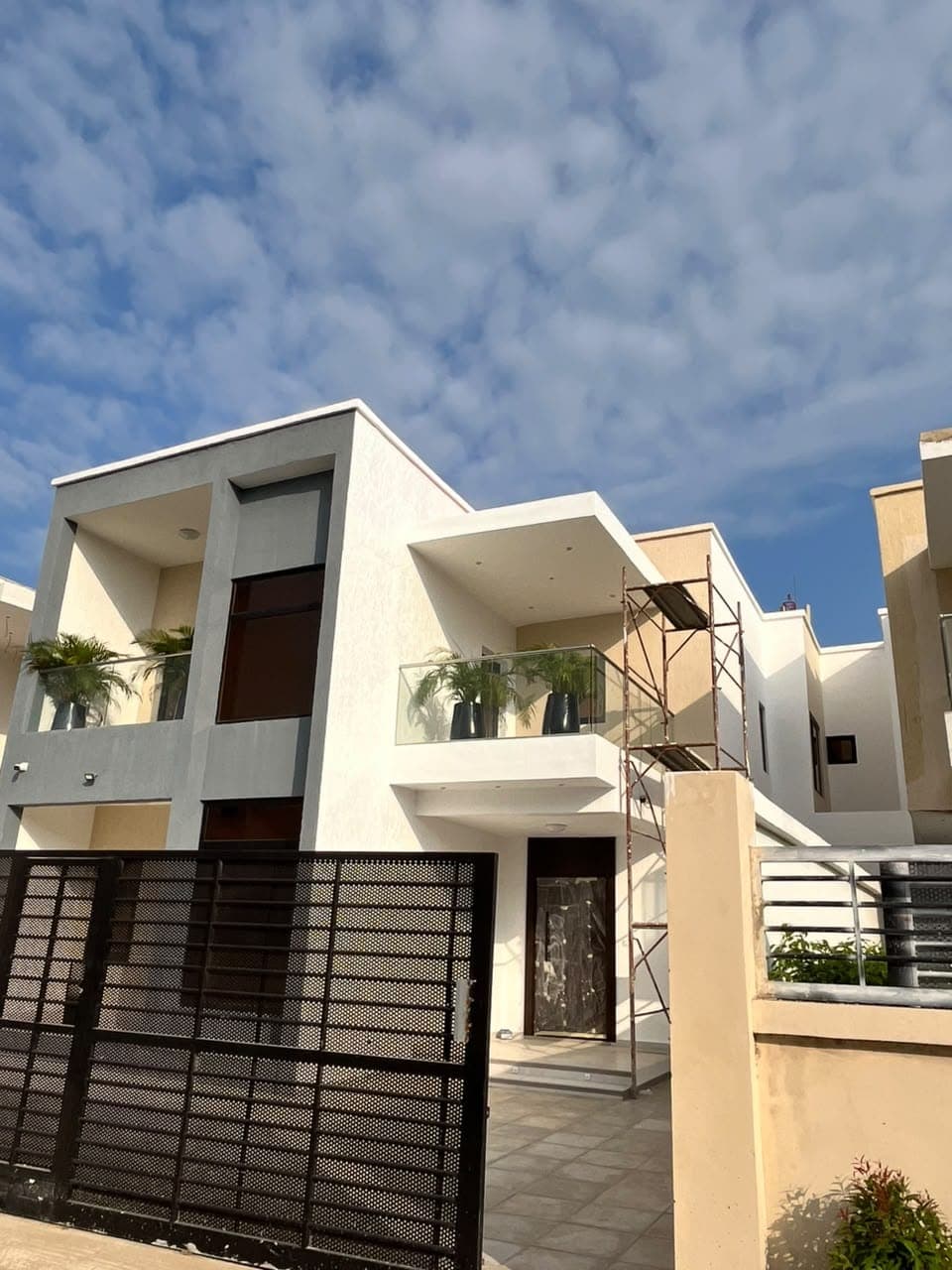 Modern house exterior finished in white, grey and warm neutral paint